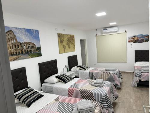 a room with three beds and a projection screen at Seven Hotel - Juana Koslay San Luis in Juana Koslay 