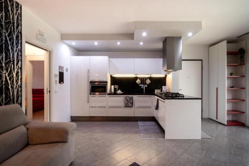 a kitchen with white cabinets and a couch in a room at Il Sogno di Elisa in Trivignano