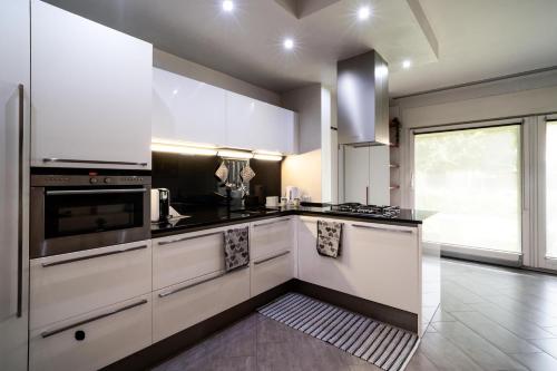a kitchen with white cabinets and a large window at Il Sogno di Elisa in Trivignano