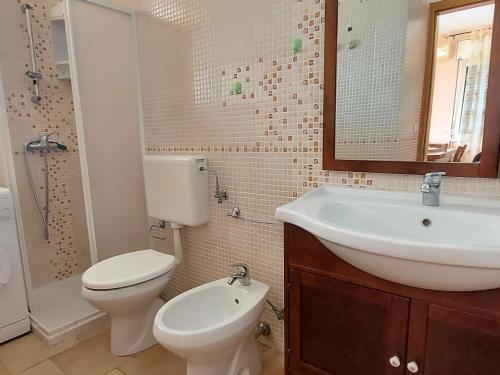 a bathroom with a toilet and a sink and a mirror at 023 e 024 Tulipano di SalentoInVacanzaCOM in Torre Pali