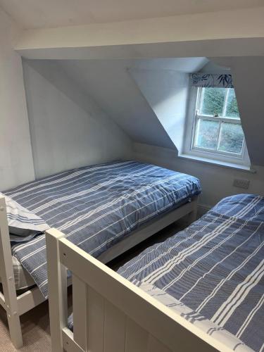 a bedroom with two beds and a window at Foretop Cottage, Staithes in Staithes
