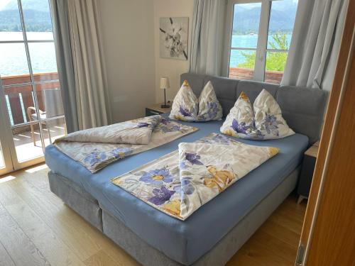 two beds in a room with a couch with pillows at Wallner am See in St. Wolfgang