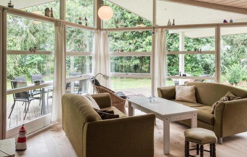a living room with large windows and a table at Holiday Home Ingerslevvej Gørlev Vi in Gørlev