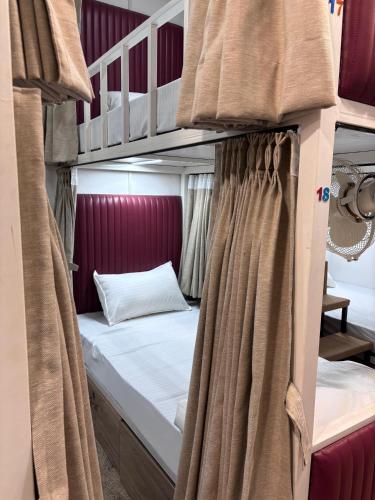 a couple of bunk beds with curtains in a room at Rajal Dormitory in Indore