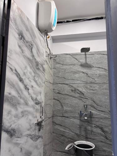 a bathroom with a marble wall and a sink at Rajal Dormitory in Indore