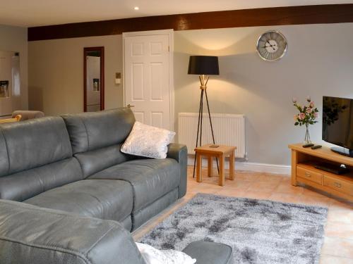 a living room with a couch and a television at Koi Keep - Ukc1909 in Doddington