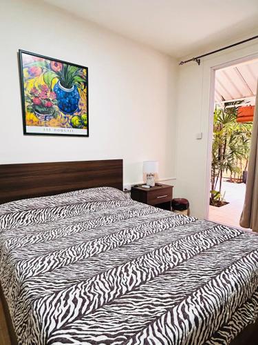a bedroom with a bed and a painting on the wall at Manuel's Apartment in Port Louis