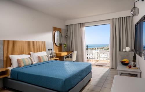 a bedroom with a bed and a view of the ocean at Mare Village in Ierapetra