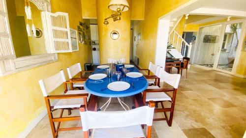 een eetkamer met een blauwe tafel en stoelen bij Charmante villa face à la mer ! in La Flotte