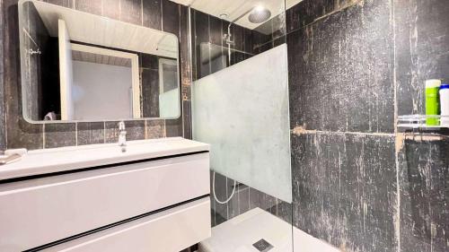 een badkamer met een wastafel en een spiegel bij Charmante villa face à la mer ! in La Flotte