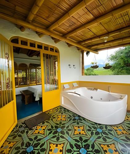a bath tub in a room with a colorful floor at FINCA HOTEL DON JULIO in Santa Rosa de Cabal