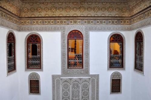 Habitación con 3 ventanas y techo. en La Maison Bleue Batha, en Fez