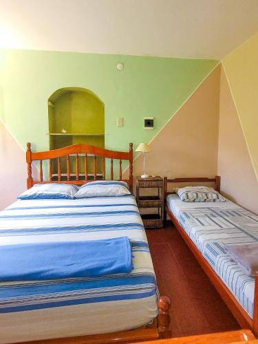 two beds in a room with green walls at Hostel - Sueños del Rio in Concepción del Uruguay