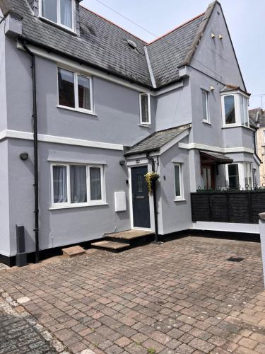 a white house with a driveway in front of it at Church Mews Central Townhouse West Hoe Plymouth in Plymouth