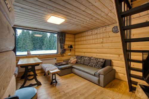 a living room with a couch in a log cabin at Pod Horou a za Potokom, Podbanské in Pribylina