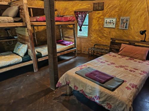 a bedroom with a bed and bunk beds in a room at Joy River Backpackers in Moremela