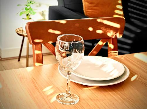 a wine glass sitting on a table with a plate at Charming Apartment Nottingham -FREE Onsite Parking -Nr City- FAST WiFi in Nottingham