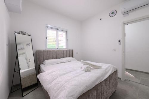 a bedroom with a large bed and a mirror at אירוח תמר in Qiryat Shemona