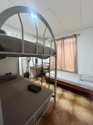 a room with two bunk beds and a table at Casa bohio surf in Jacó