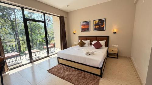 a bedroom with a large bed and a balcony at Coorg Homes in Madikeri