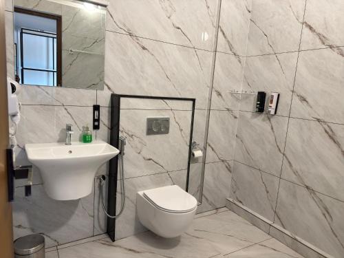 a bathroom with a toilet and a sink at Coorg Homes in Madikeri