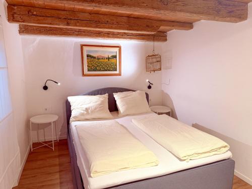 a bedroom with a bed with white sheets at Holy View Apartment in Bolzano
