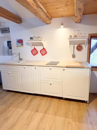 a kitchen with white cabinets and a sink at Holy View Apartment in Bolzano