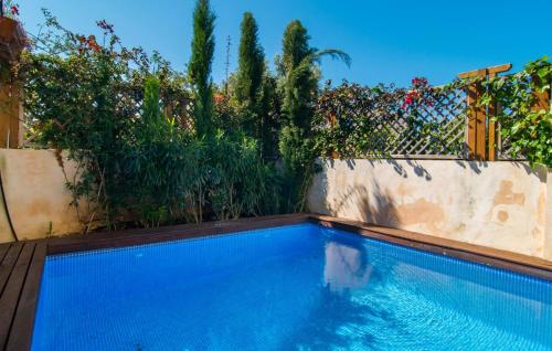 a swimming pool in a garden with a fence at La Casa De Los Espejos in Capdepera