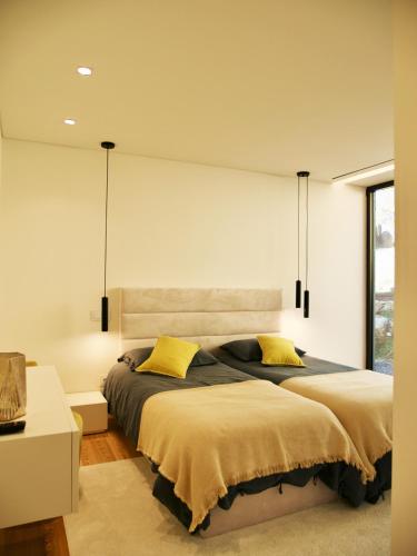 a bedroom with two beds with yellow pillows at Casa da Merelhe in Marco de Canaveses