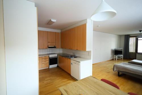 a kitchen and living room with a table and a couch at LibO-apartment, Rypys 74 X in Kuopio