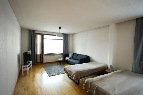 a hotel room with two beds and a couch at LibO-apartment, Rypys 74 X in Kuopio