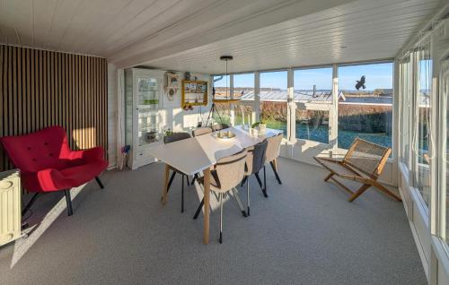 a dining room with a table and chairs and the ocean at 3 Bedroom Cozy Home In Haderslev in Haderslev