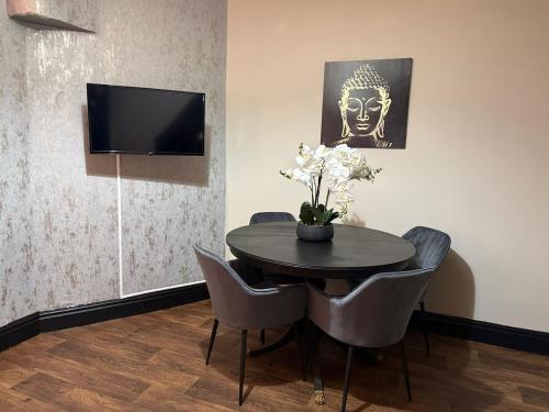 a dining room with a table with chairs and a tv at Byelands House in Middlesbrough