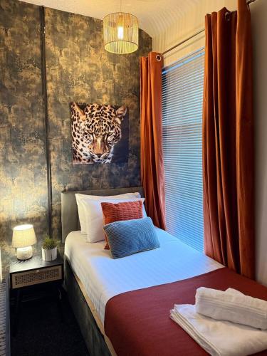 a bedroom with a bed with a painting of a leopard at Byelands House in Middlesbrough