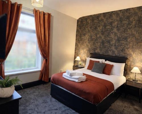 a bedroom with a bed and a large window at Byelands House in Middlesbrough