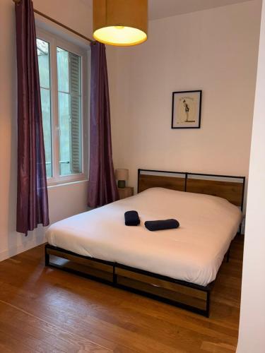 a bedroom with a bed with white sheets and a window at Larbaud 6 - Hypercentre - Proche Thermes - Spacieux in Vichy