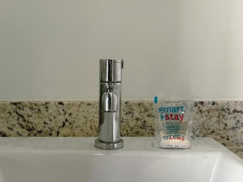 a faucet on top of a sink in a bathroom at Apto Moderno no Coração da Cidade - CA802 in Maringá