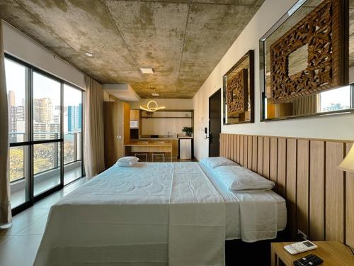 a bedroom with a large bed and large windows at Apto Moderno no Coração da Cidade - CA802 in Maringá