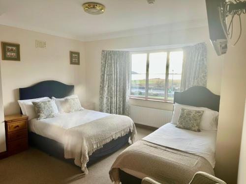 a bedroom with two beds and a window at Seashore Lodge Guesthouse in Galway