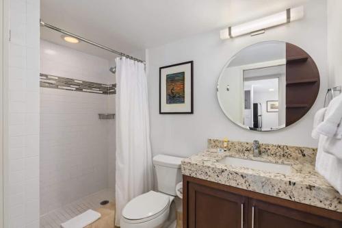 a bathroom with a toilet and a sink and a mirror at #Marbella Lane - Luxe 2BR with Panoramic Ocean View in Honolulu