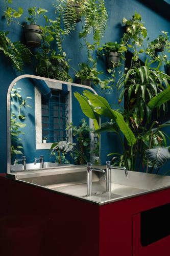 a bathroom with a sink with plants on the wall at Esqina Cosmopolitan Lodge in Lisbon