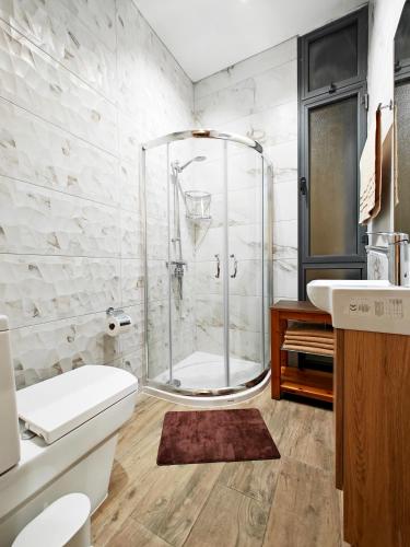a bathroom with a shower and a toilet and a sink at Ivy in Is-Swieqi