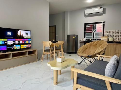 a living room with a tv and a table and chairs at Angie Tiny House near Krabi Airport with Free Airport Shuttle