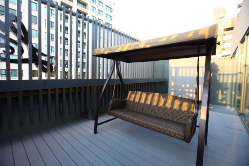 a chair sitting on a balcony with a table at Hotel Lainn in Kaohsiung