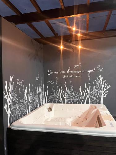a wall with a bath tub in a room at Pousada Vila do Meio in Pinheiro