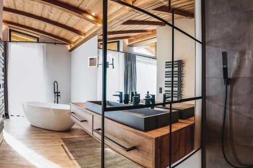 a bathroom with a tub and a sink and a bath tub at Chalet Amadeus by we rent in Piesendorf