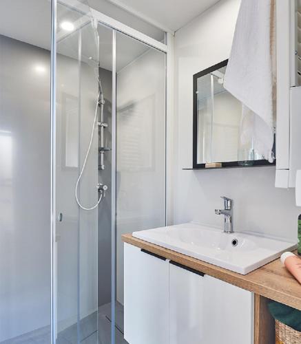 a white bathroom with a sink and a shower at Camping l'Oso in Porto-Vecchio