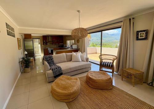 a living room with a couch and a table at Spacious sunny secure and central with scenic views in Hout Bay
