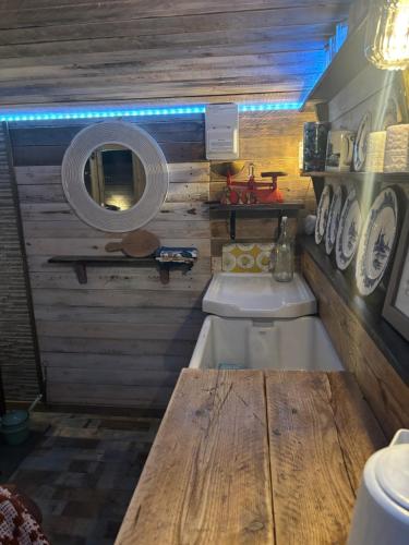 a bathroom with a tub and a sink and a mirror at Yellowhammer Hut at Carr House Farm in Cayton