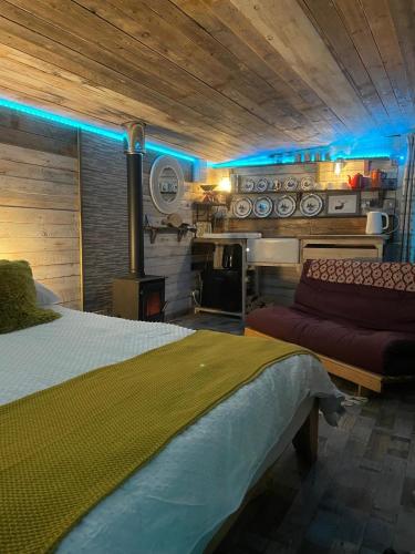 a bedroom with a bed with blue lights on it at Yellowhammer Hut at Carr House Farm in Cayton